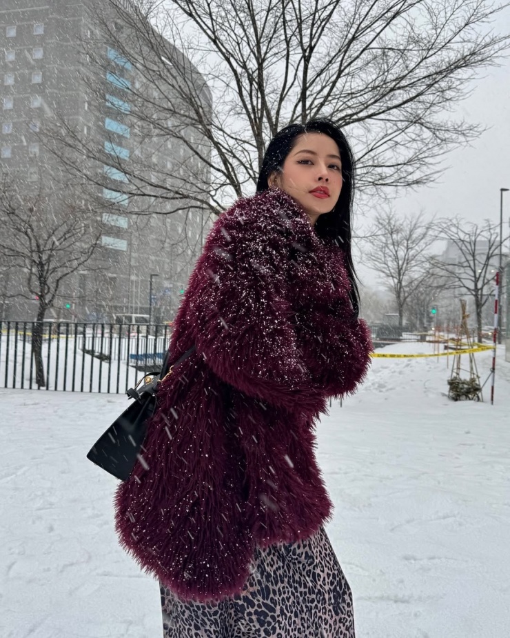 Trong chuyến đi Hokkaido, Nhật Bản đầu năm ngoái, cô chọn áo đỏ tía phối đầm họa tiết da báo, mũ lông và bốt.
