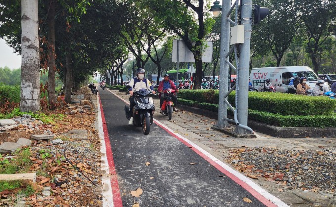 Làn đường được lát đá, trải nhựa kẻ vạch dành riêng cho xe đạp trên vỉa hè bị xe máy chạy vào. Ảnh: Đình Văn