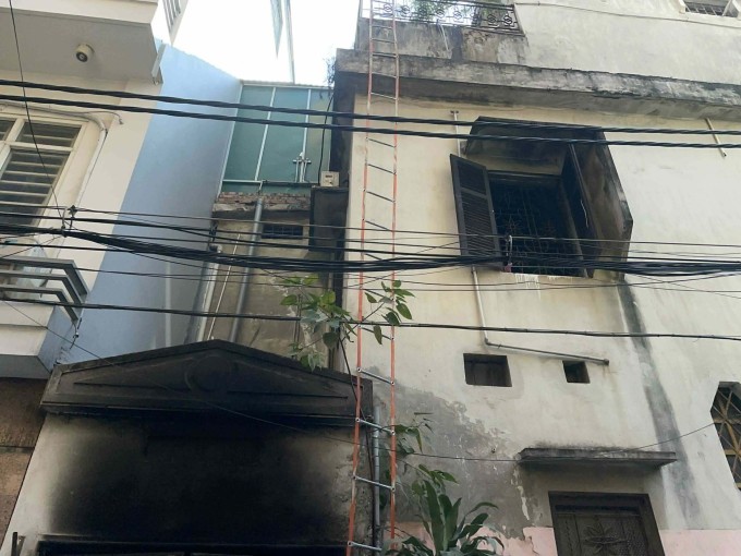 Ngôi nhà cháy bị ám khói với thang dây các nạn nhân thoát xuống dưới. Ảnh: Việt An