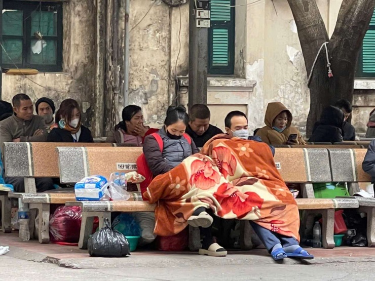 Không hiếm hình ảnh người dân đắp chăn ngồi, nằm trên ghế đá tại Bệnh viện Việt Đức tranh thủ chợp mắt trong những ngày Hà&nbsp;Nội rét sâu. Ảnh: N.T