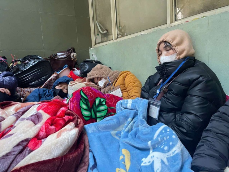 Một số người nhà bệnh nhân tìm kiếm những góc tường rồi chất đồ, nằm túm tụm, đắp chăn co ro chống rét. Ảnh: N.T