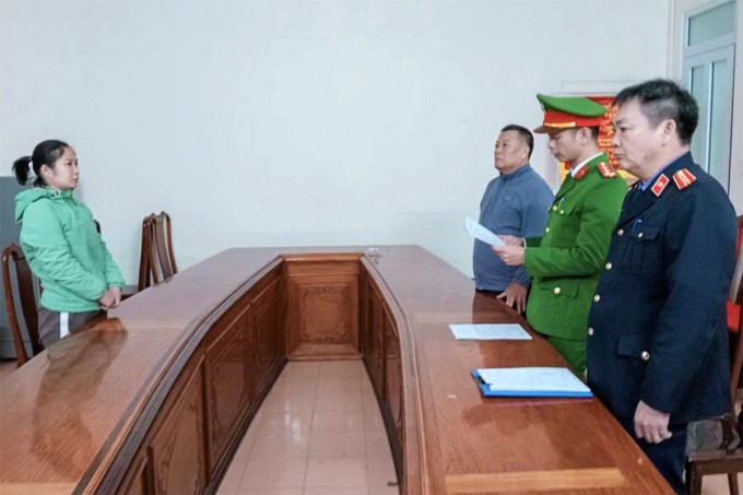 Nghi can Hà (góc trái), nghe cảnh sát đọc lệnh khởi tố. Ảnh: VKS cung cấp