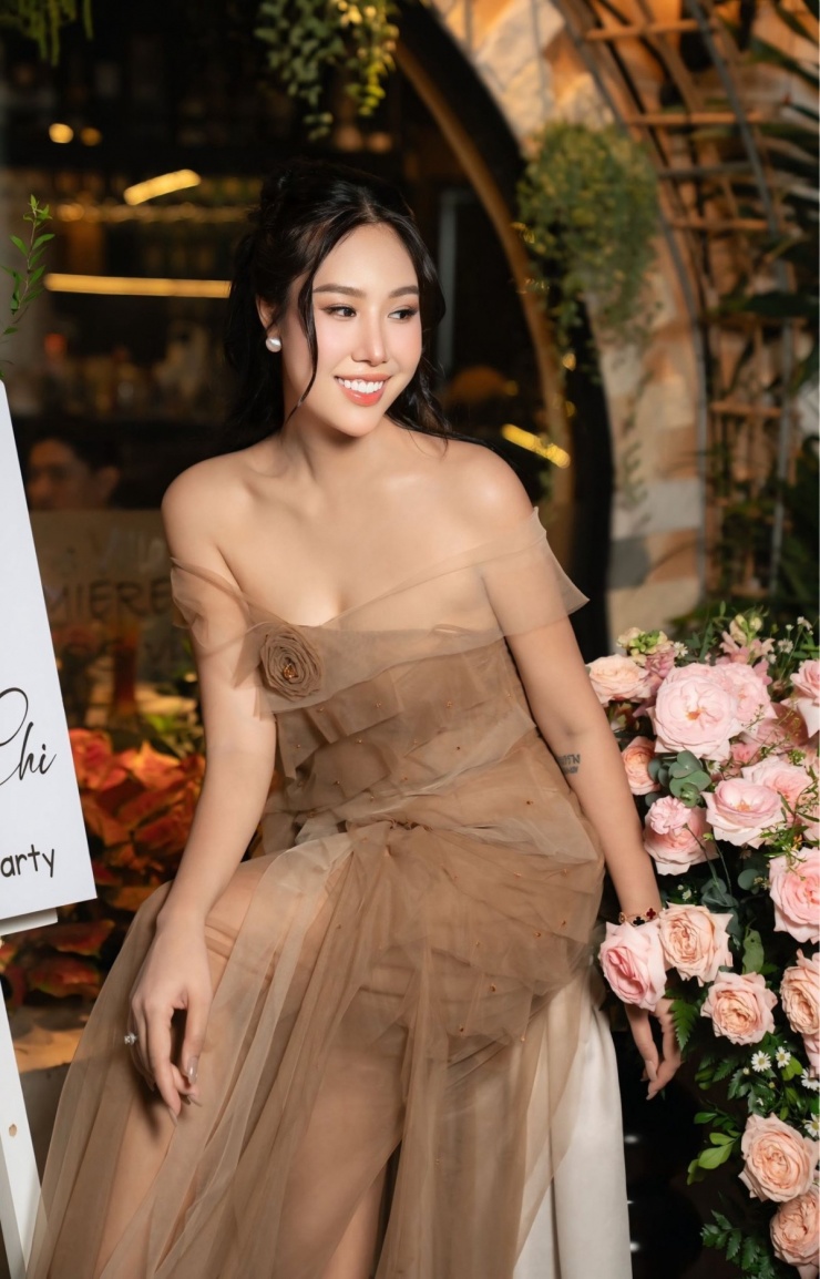 Trong bữa tiệc mừng tuổi mới năm ngoái, cô chọn đầm xuyên thấu hở vai, trang điểm tông hồng cam.