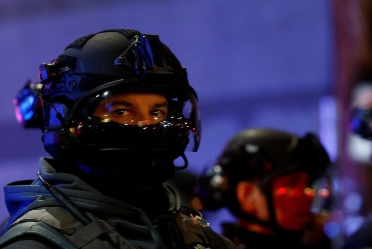 Người biểu tình và cảnh sát chống bạo động bên ngoài trụ sở ICE ở Portland. (Ảnh: Reuters)