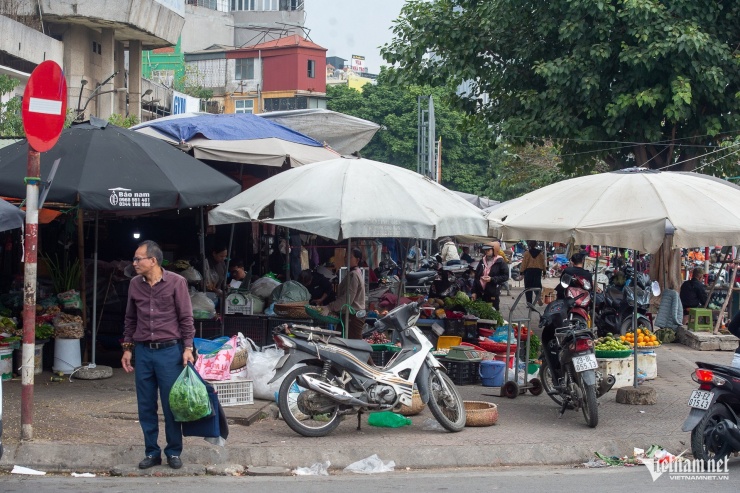 Ngoài ra, trên địa bàn Hà Nội vẫn còn nhiều chợ cóc, chợ tạm không nằm trong danh sách bị giải tỏa nhưng đang hoạt động mua bán tấp nập. Trong ảnh, khu vực chợ cóc chi chít ô dù trên vỉa hè rộng rãi tại Ngã Tư Sở.&nbsp;