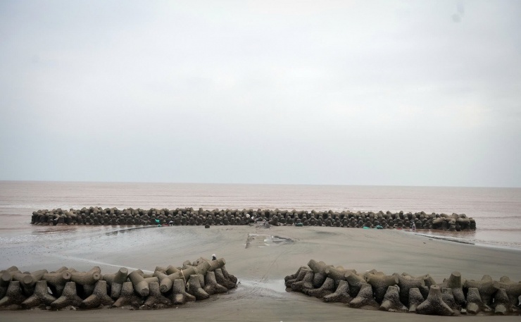 Dưới cái lạnh "cắt da cắt thịt", họ phải lội nhiều giờ liền trong nước biển lạnh như băng, cúi khom người, dùng nẫy sắt đục mạnh từng nhát để tách vẹm khỏi bề mặt bê tông. Công việc tưởng chừng đơn giản nhưng đòi hỏi sức khỏe, sự dẻo dai và khả năng chịu đựng thời tiết khắc nghiệt. Ảnh: Vũ Quỳnh.