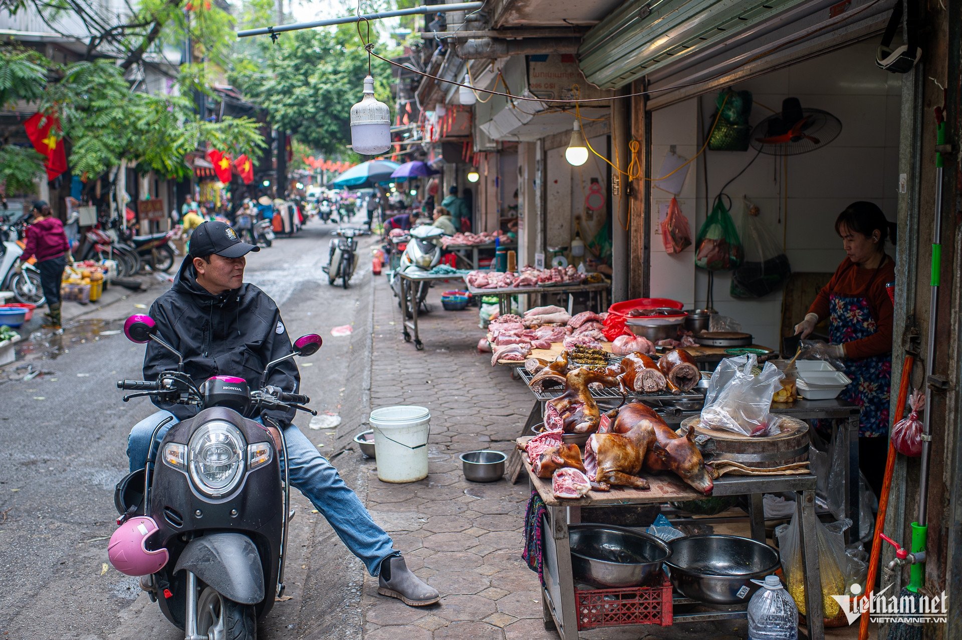 Các sạp hàng kinh doanh rau xanh, hoa quả, thịt, cá và nhiều mặt hàng thực phẩm khác được bày bán nhếch nhác dọc tuyến đường, kéo dài liên tục và chiếm dụng gần như toàn bộ phần vỉa hè dành cho người đi bộ.
