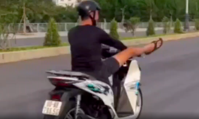 Thanh niên dùng chân điều khiển xe máy. Ảnh: Người dân cung cấp