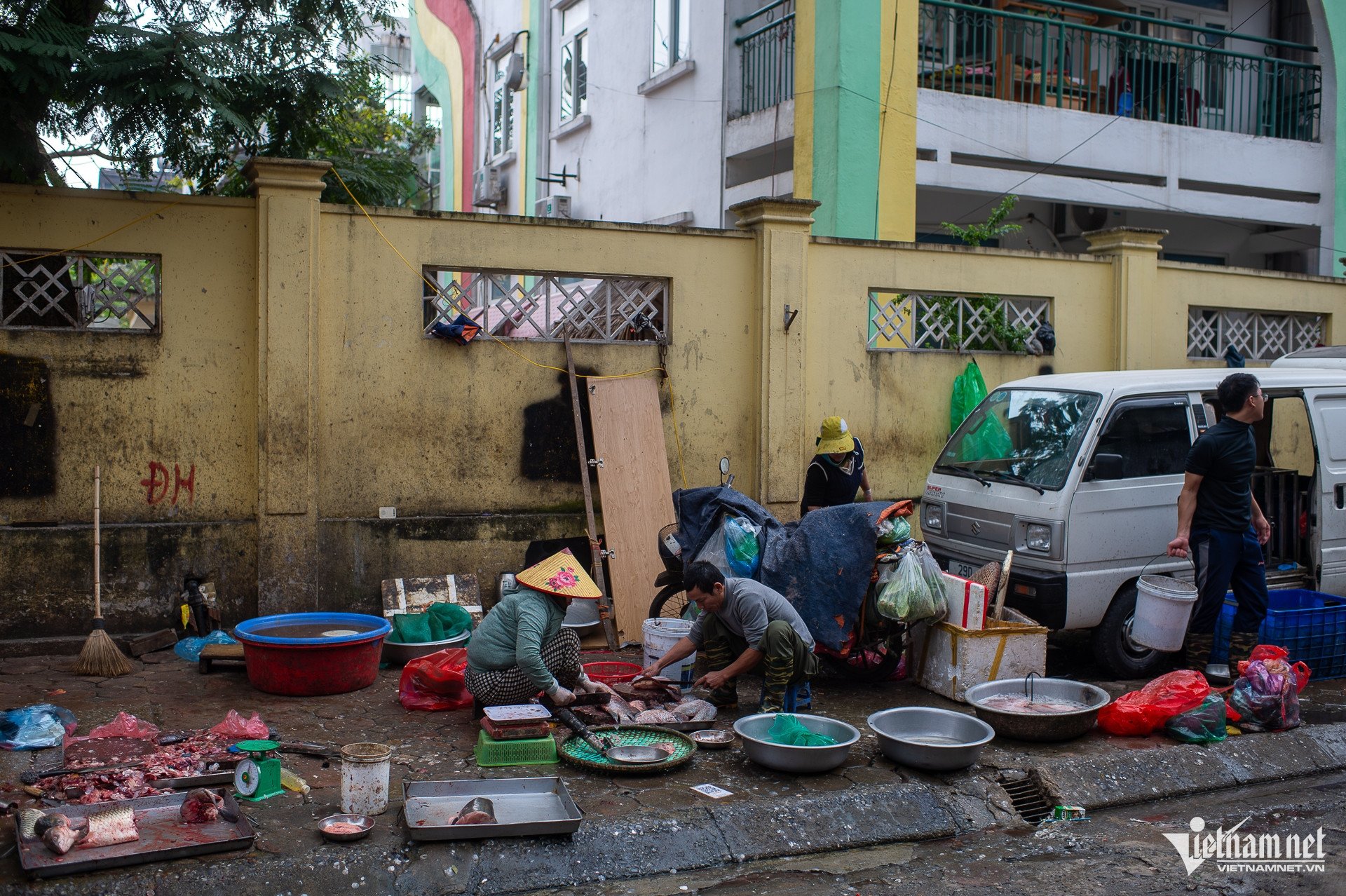 Các sạp hàng kinh doanh rau xanh, hoa quả, thịt, cá và nhiều mặt hàng thực phẩm khác được bày bán nhếch nhác dọc tuyến đường, kéo dài liên tục và chiếm dụng gần như toàn bộ phần vỉa hè dành cho người đi bộ.
