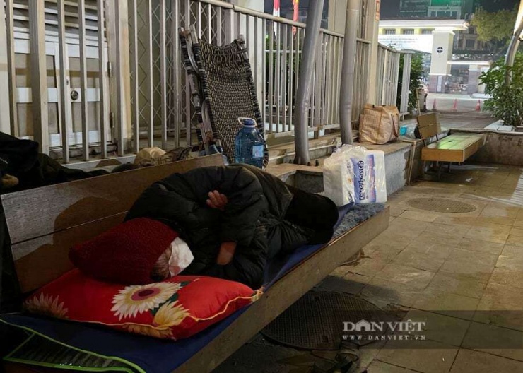 Cách đó không xa, một người nhà bệnh nhân kê tạm tấm đệm mỏng, mặc kín quần áo để xua đi cái lạnh vì không kịp chuẩn bị chăn màn.