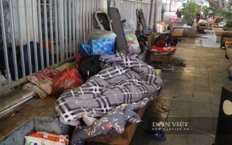 Người nhà bệnh nhân cuộn chăn tránh rét, nghỉ ngơi trong đêm trước phòng cấp cứu Bệnh viện Bạch Mai