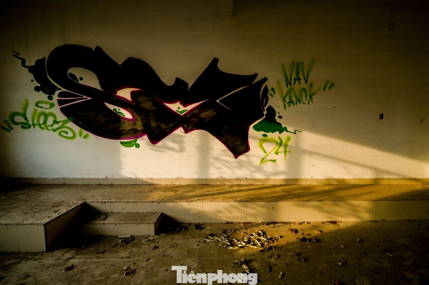 Trên các mảng tường thô chằng chịt những nét vẽ graffiti, dấu tích của sự xâm nhập tự do vào công trình.