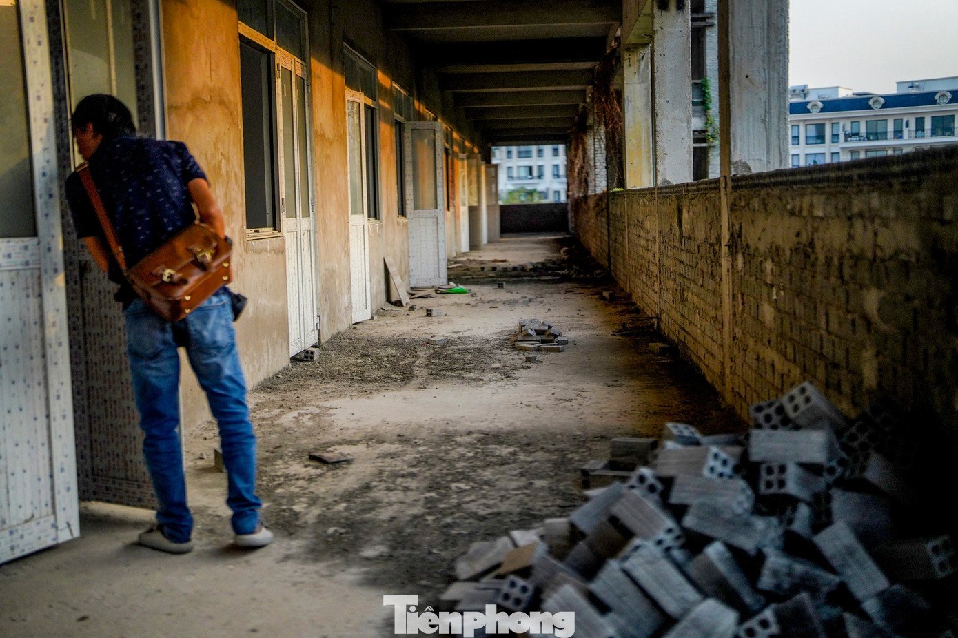 Vật liệu nằm chỏng chơ, phủ bụi giữa những bức tường xây dở.