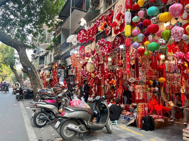 Trên các sạp hàng, những chiếc đèn lồng đỏ, câu đối, bao lì xì, dây treo chữ Phúc – Lộc – Thọ, quạt giấy trang trí, phụ kiện treo cửa, linh vật năm mới… được sắp xếp dày đặc.