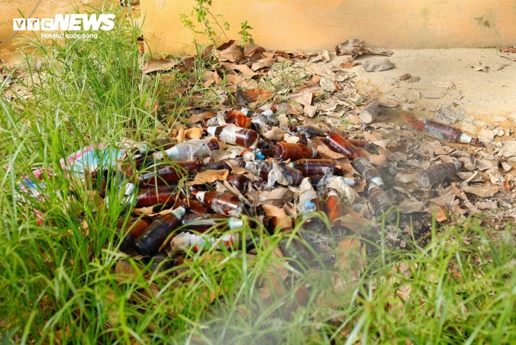 Những lớp bùn đọng lại sau lũ thành lớp dày phủ kín nền nhà và vương vãi khắp bề mặt tường. Xen lẫn đó là lá cây, vỏ chai bia nằm ngổn ngang khiến nhiều người ngán ngẩm. (Ảnh: Sỹ Nhất)