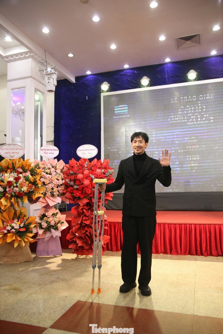 Diễn viên Tuấn Trần chống nạng tới dự lễ trao giải vì chấn thương khi quay Hộ lính tráng sĩ. Anh cũng tham gia phim điện ảnh ra rạp dịp Tết Nguyên đán 2026 - Báu vật trời cho của đạo diễn Lê Thanh Sơn và Trần Khánh Hoàng.