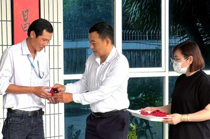 Đại diện công ty trao tặng vàng cho công nhân gắn bó lâu năm. Ảnh: Minh Bằng