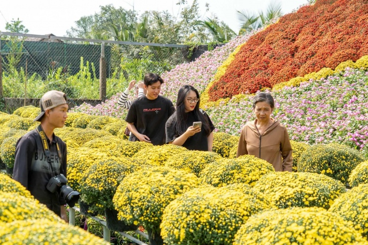 Các lối đi giữa những giàn hoa trở thành điểm check-in quen thuộc. Từng nhóm bạn trẻ, gia đình, du khách từ TP.HCM và các tỉnh lân cận thong thả dạo bước, chụp ảnh, tận hưởng không khí xuân đang dần lan tỏa.