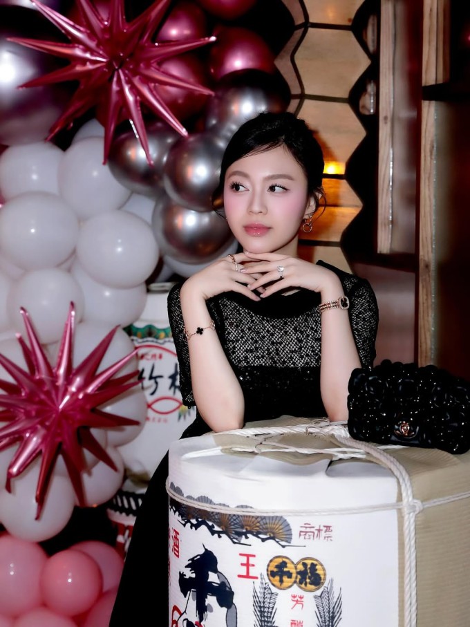 Trong một lần sự kiện gần đây, Ruby Khánh Linh diện váy đen với các khoảng hở vừa phải, phối cùng túi đính hoa trà cùng tông của Chanel. Cô còn tô điểm phong cách bằng phụ kiện đến từ các nhà mốt xa xỉ, dành cho giới nhà giàu như: đồng hồ nạm kim cương của Patek Philippe, lắc tay Van Cleef &amp; Arpels, nhẫn ngón trỏ của Cartier... bên cạnh nhẫn cưới đính kim cương.