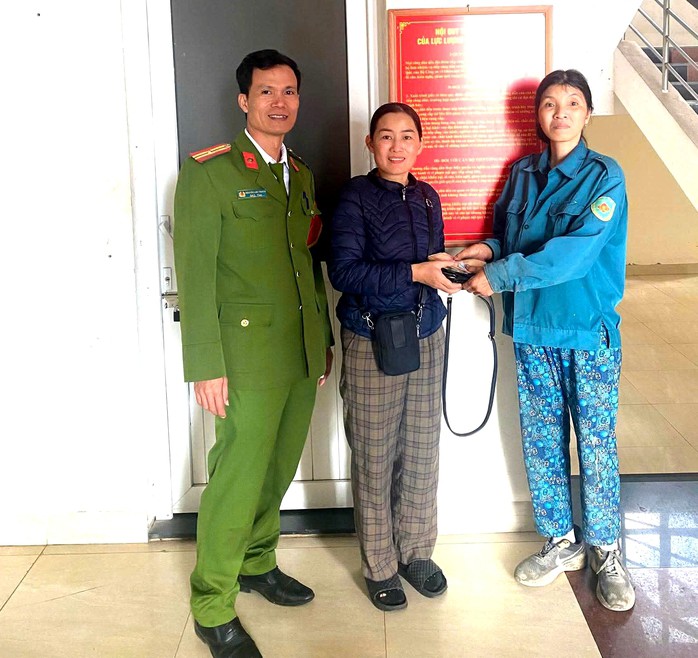 Chị Trần Thị Hoa Lý (bên phải) trao trả chiếc túi xách cho người đánh rơi. Ảnh: Công an Vĩnh Linh