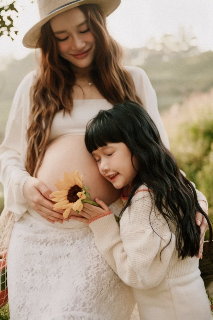 Bà xã Trường Giang còn mặc bra top kèm chân váy ren khoe bụng bầu vượt mặt, không quên bổ sung áo choàng mỏng và mũ phớt phù hợp không gian nên thơ tại Đà Lạt.