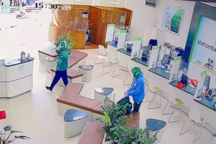 Hai tên cướp buộc chặt túi xách trước khi rời khỏi hiện trường. Ảnh cắt từ clip