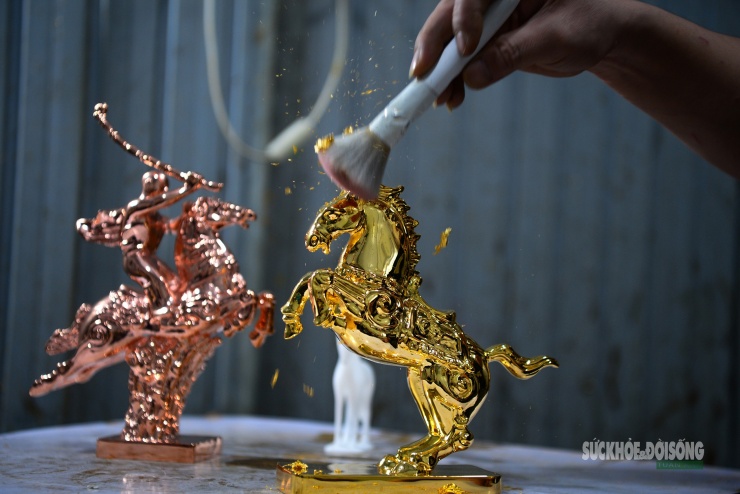 Công đoạn dát vàng thủ công được thực hiện tỉ mỉ, từng lớp vàng kim tạo nên sắc ánh rực rỡ cho linh vật.