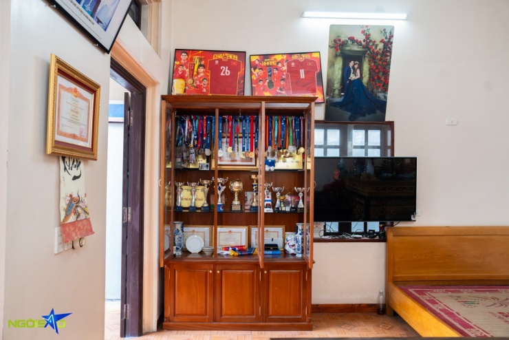 Phía bên trong phòng khách được bố trí một tủ kính lớn trưng bày các danh hiệu, huy chương, cúp và bằng khen trong quá trình thi đấu của đội trưởng U23 Việt Nam, đặt trang trọng giữa không gian sinh hoạt chung.