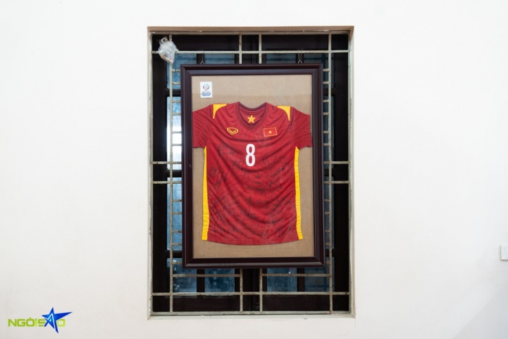 Chiếc áo đấu của đội tuyển U23 Việt Nam, in số 8 và có đầy đủ chữ ký của các cầu thủ tại giải AFC U23 Asian Cup Uzbekistan 2022, được đóng khung và treo trang trọng ở vị trí trung tâm phòng khách.
