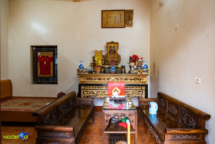 Không gian sinh hoạt được bài trí giản dị, gồm giường đôi, bộ bàn ghế gỗ tiếp khách và bàn thờ gia tiên.