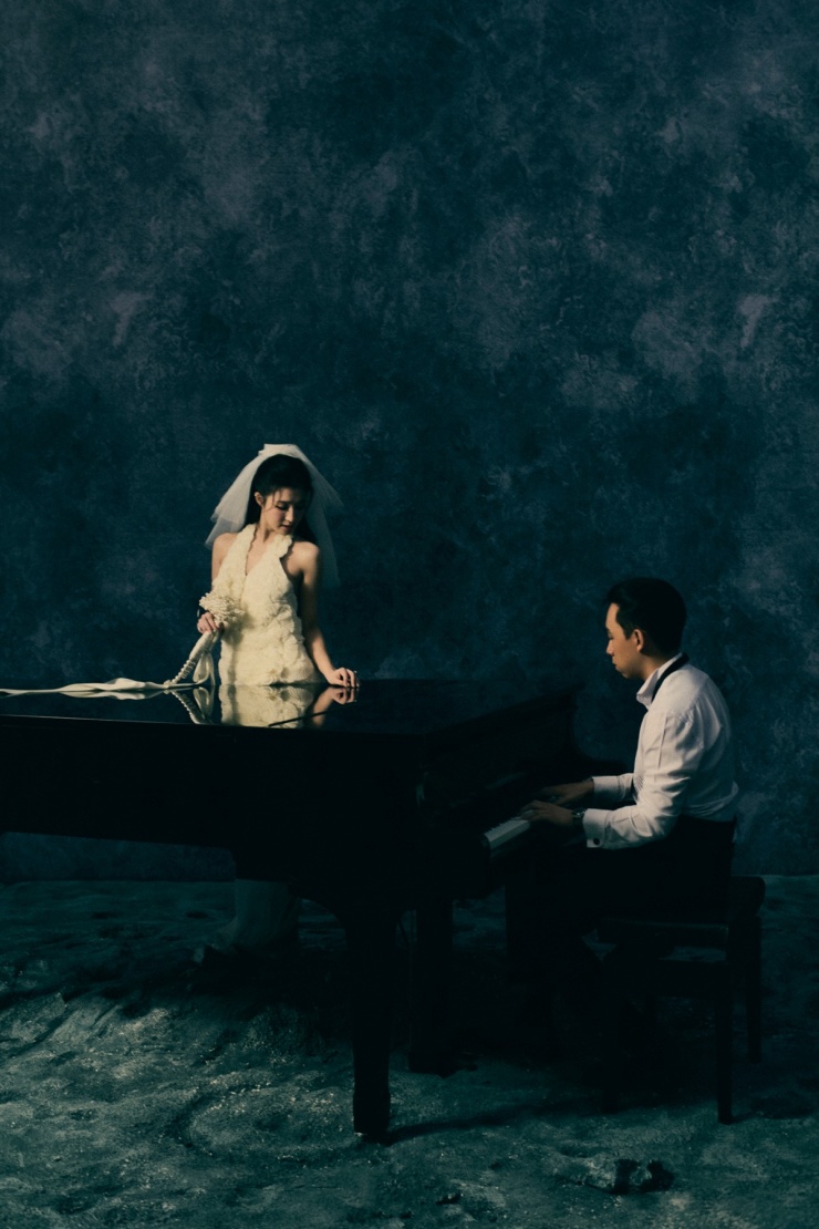 Cũng trong bộ ảnh cưới, Phương Nhi - Minh Hoàng còn tạo dáng bên đàn piano. Toàn bộ series được đặt trong không gian studio tối màu, nền tường loang xanh xám, tạo nên những khung hình tựa như thước phim.