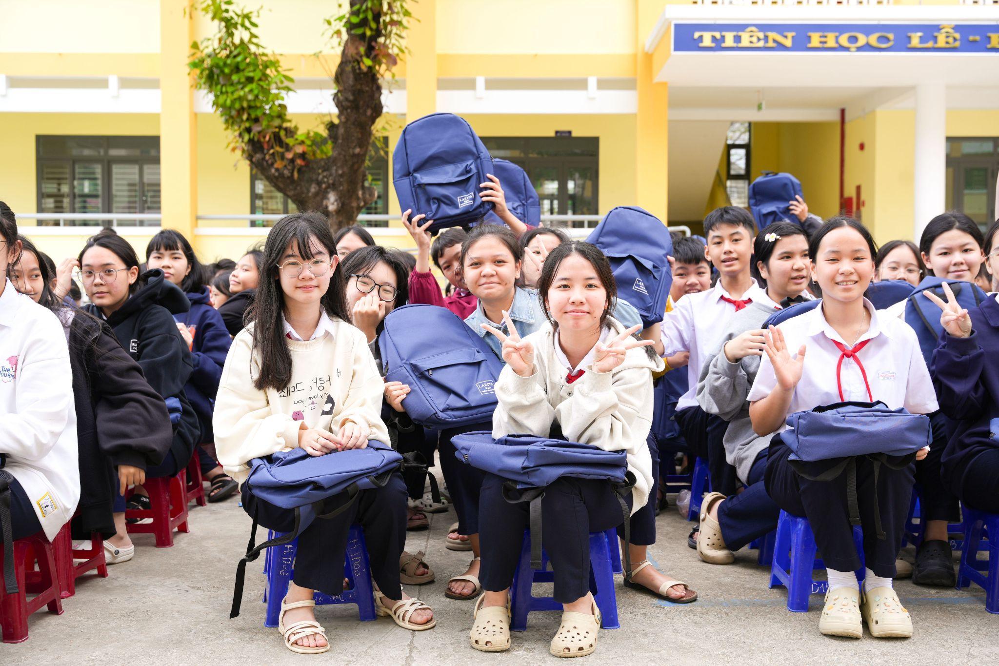 Học sinh nhận balo mới trong khuôn viên trường học.