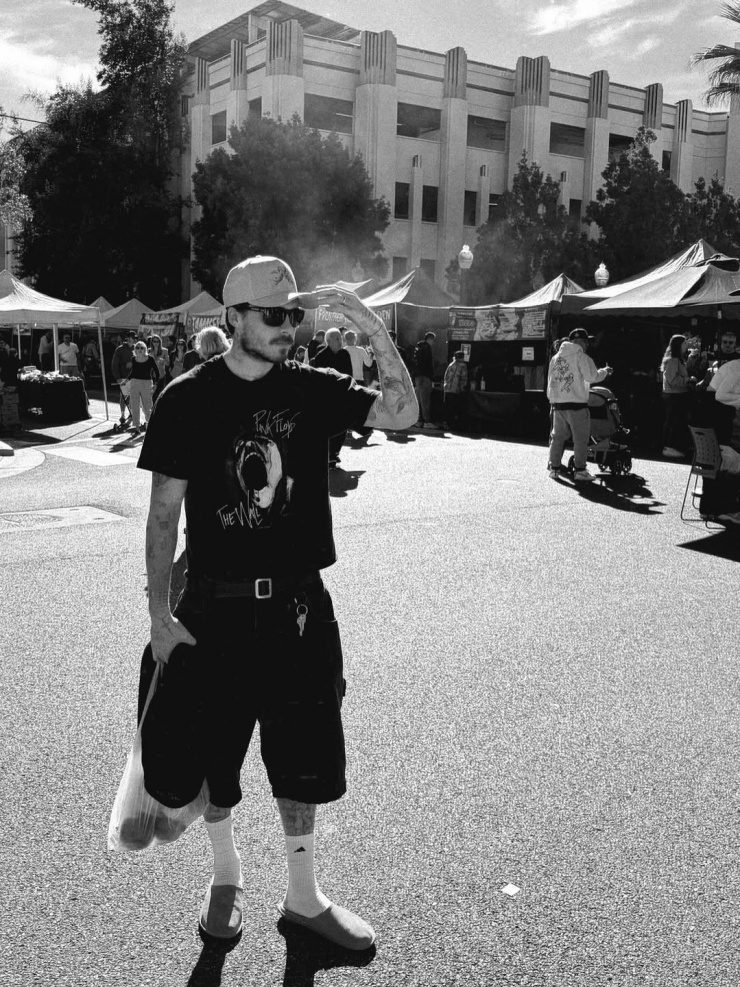 Hôm 16/1, Brooklyn Beckham chia sẻ ảnh dạo chơi ở một khu chợ nông sản. Anh diện áo phông cảm hứng rock, quần shorts bermuda, đội mũ lưỡi trai và đi dép sục. Từ ngày cưới diễn viên Nicola Peltz năm 2022, anh thường xuyên mặc phong cách này, hướng đến sự thoải mái, phóng khoáng. Ảnh: Instagram Brooklyn Beckham