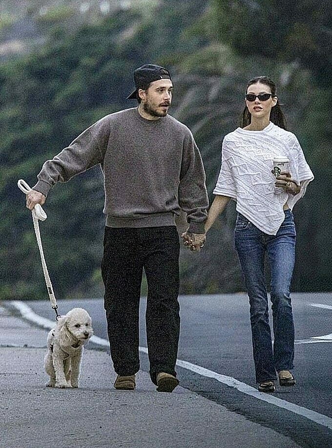 Cặp vợ chồng trẻ nắm tay không rời trên đường. Ảnh: Backgrid