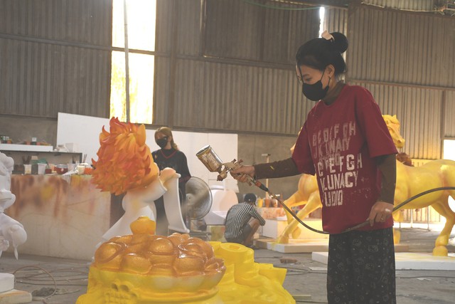 Nhóm công nhân sơn màu, hoàn thiện cho các linh vật. Trung bình mỗi sản phẩm mất từ vài ngày đến nửa tháng để hoàn thành, tùy kích thước và độ phức tạp. Với linh vật kích thước nhỏ thì vẽ đơn giản, còn những con nhiều chi tiết thì phức tạp hơn nhất là phần đầu.