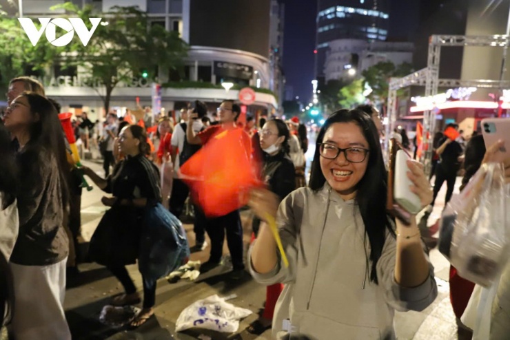 Hạnh phúc đơn giản là được hòa mình vào dòng người. Một cổ động viên nữ cười hết cỡ, vẫy cờ nhiệt tình trong đám đông. Sự mệt mỏi sau những phút hồi hộp theo dõi loạt