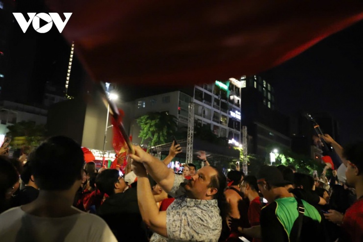 Bóng đá xóa nhòa mọi biên giới. Một người bạn nước ngoài hòa chung nhịp đập với người hâm mộ Việt Nam, trân trọng nâng cao lá cờ đỏ sao vàng.