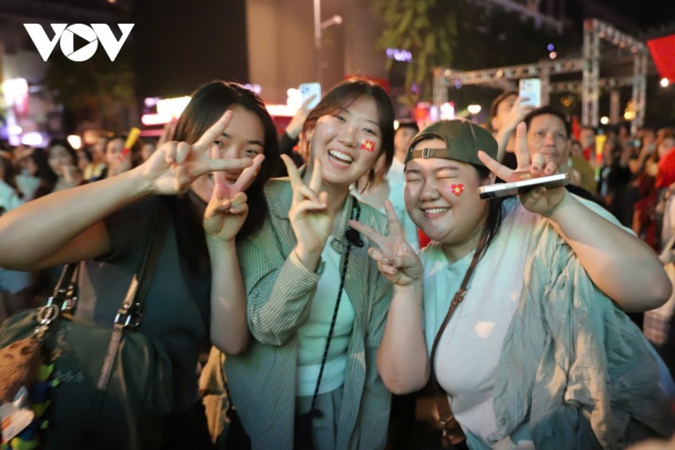 Nụ cười chiến thắng trên môi những cô gái. Các bạn trẻ tranh thủ ghi lại khoảnh khắc đáng nhớ ngay giữa biển người trong đêm.