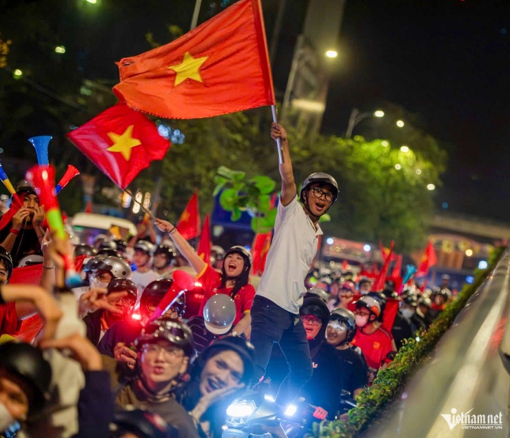 Nhiều bạn trẻ mang theo cờ Tổ quốc reo hò, bắt tay người đi đường mừng U23 Việt Nam. Hình ảnh trên đường Tôn Đức Thắng, phường Sài Gòn.