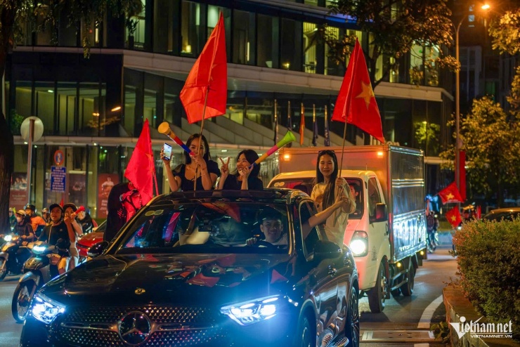 Một số cô gái phấn khích nhảy múa hò reo trong dòng người.