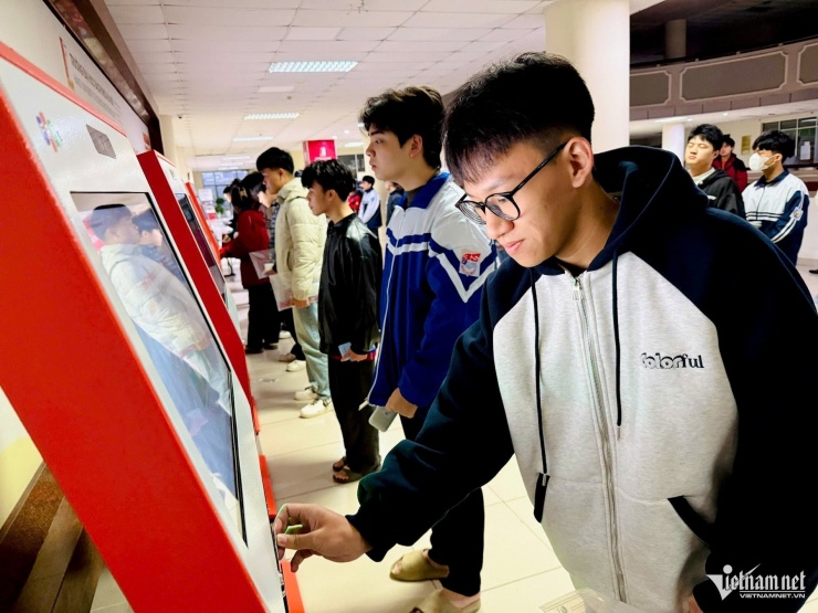 Thí sinh làm thủ tục dự thi tự động, lấy phiếu dự thi để vào phòng thi. Ảnh: Thúy Nga