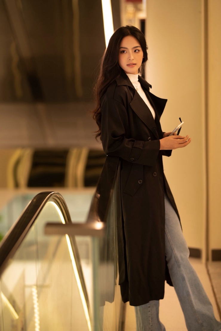 Chiếc áo khoác dáng dài phối cùng áo thun trắng và quần jeans mang đến sự trẻ trung, năng động, phù hợp với mọi hoàn cảnh. Phụ kiện nhỏ như dây chuyền tinh tế và kính mát hiện đại làm nổi bật cá tính thời trang đầy cuốn hút của Á hậu quê Hải Phòng.