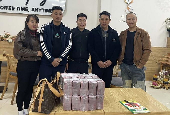 Anh Nguyễn Văn Huấn (đứng giữa) trao lại một tỷ tiền mặt cho vợ chồng chị Vân (trái) tại xã Tiên Lục, tỉnh Bắc Ninh, chiều 23/1. Ảnh: Nhân vật cung cấp