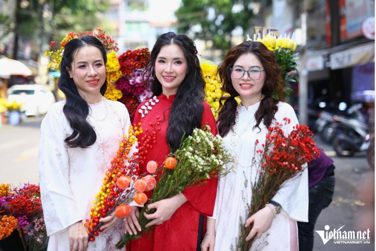 Những người bạn trong tà áo dài truyền thống rạng rỡ tạo dáng chụp ảnh bên xe hoa tại chợ Biên Hòa, vẻ đẹp tươi tắn và đậm chất Tết xưa.