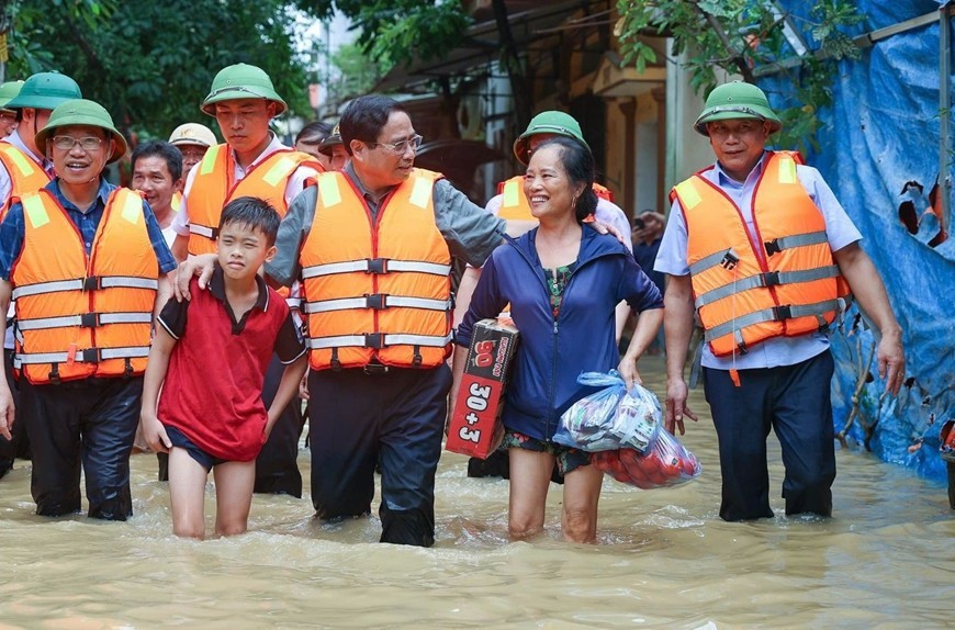Thủ tướng đi kiểm tra và thăm hỏi người dân trong vùng bị lụt, bão.