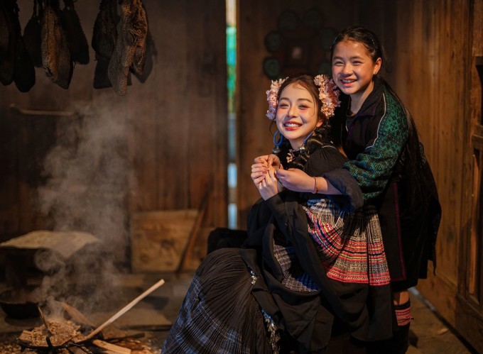 Jennifer Phạm tạo dáng cùng một em bé người H'Mông ở bản Cát Cát.