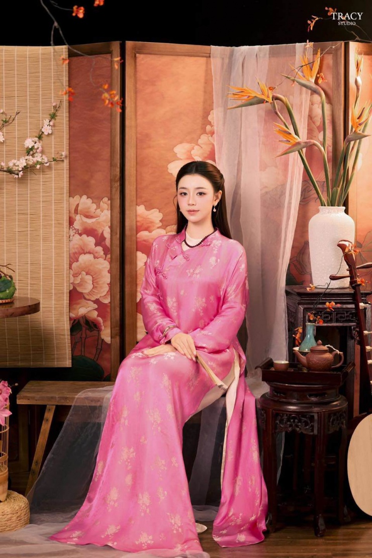 Thiết kế áo dài hồng phấn của Quỳnh Kool không chỉ đẹp về mặt thị giác mà còn thông minh trong việc kết hợp chất liệu lụa mỏng với họa tiết thêu nổi, giúp tránh cảm giác nặng nề, đồng thời tạo hiệu ứng ánh sáng tốt khi chụp ảnh.