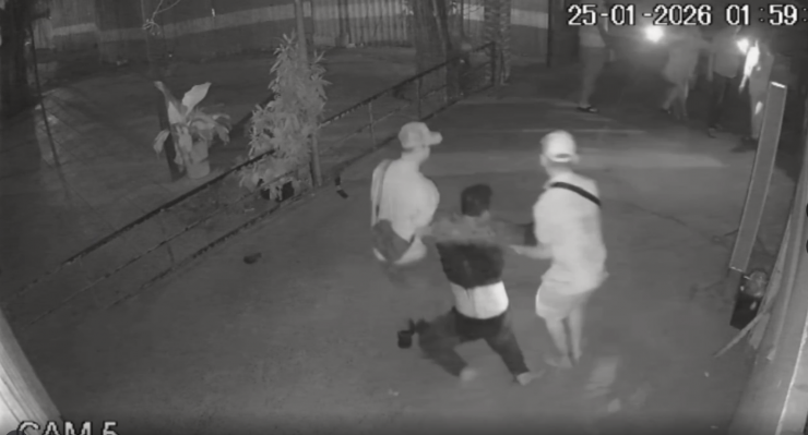 Thanh niên bị đánh được người dân dìu lên xe cứu thương.