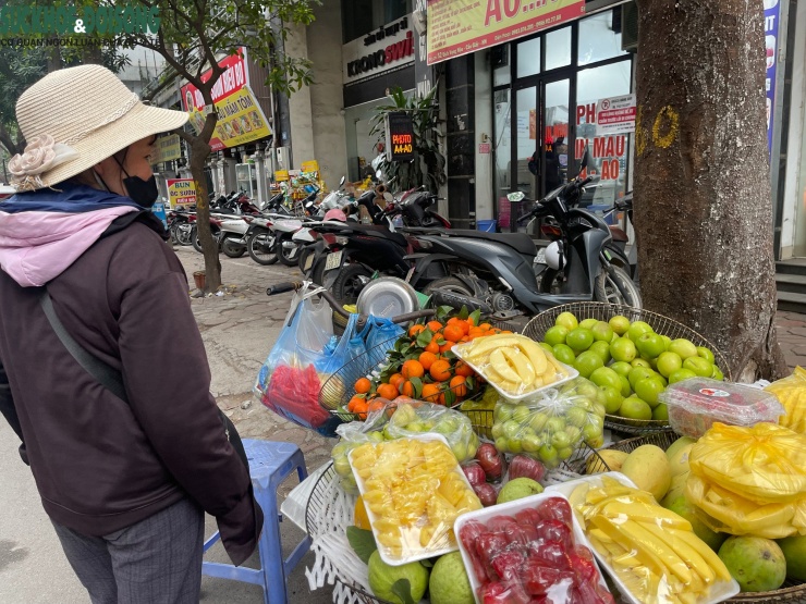 Chị Nguyễn Thị Hòa bên gánh hàng rong hoa quả.