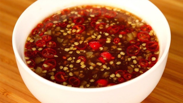 Giã tỏi và ớt rồi cho vào nước mắm me, khuấy đều. Nước mắm có màu nâu và vị chua thanh của me, thơm và đậm đà.